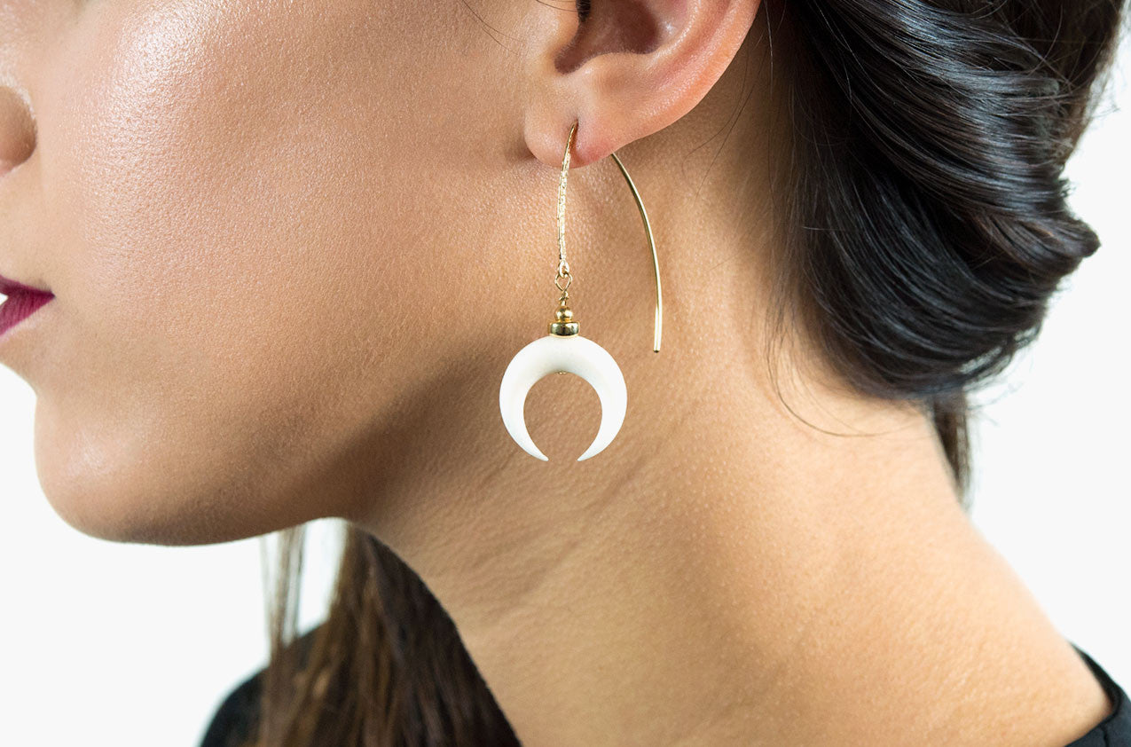 Model wearing Little Big Horn. Crescent medium drop earrrings Ivory with 14kt gold hammered earwires