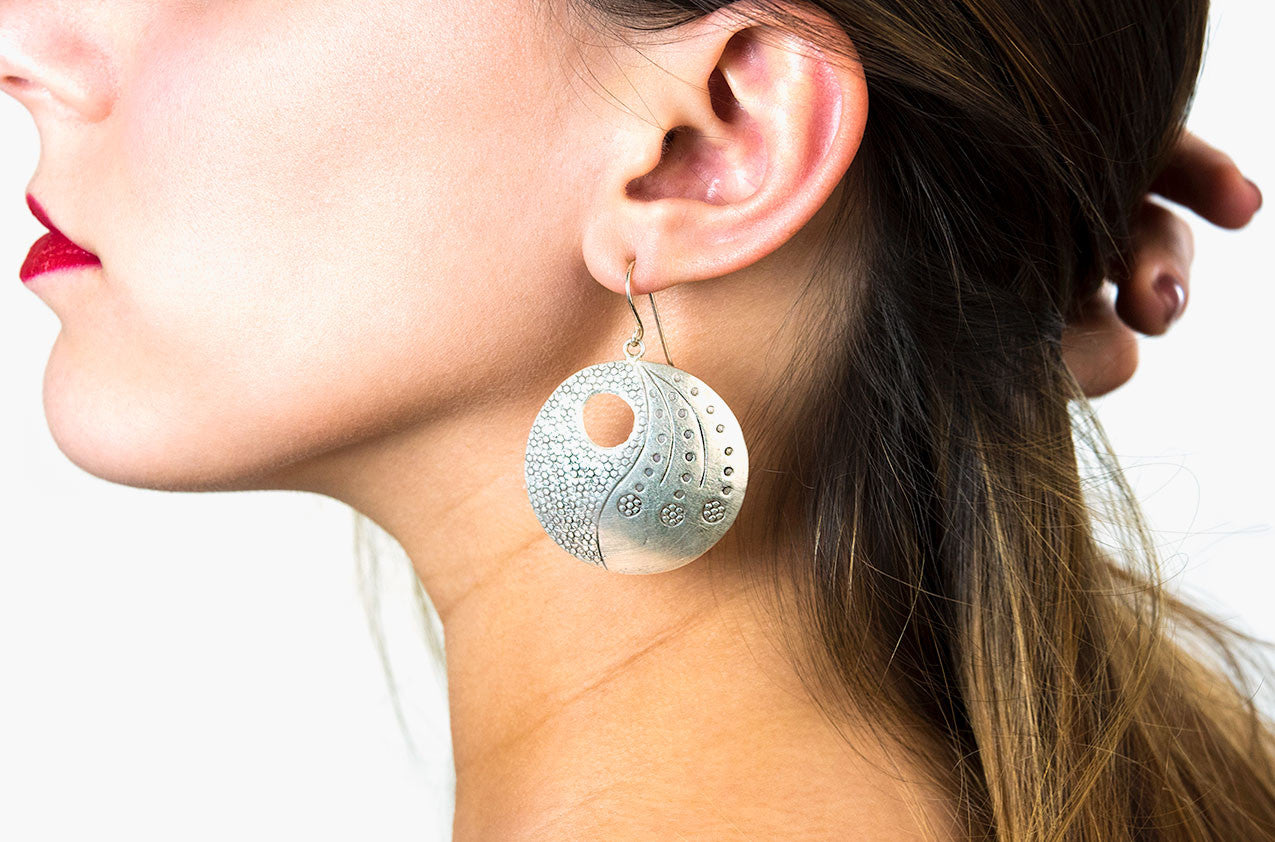 Model wearing Big Wheel silver statement earrings