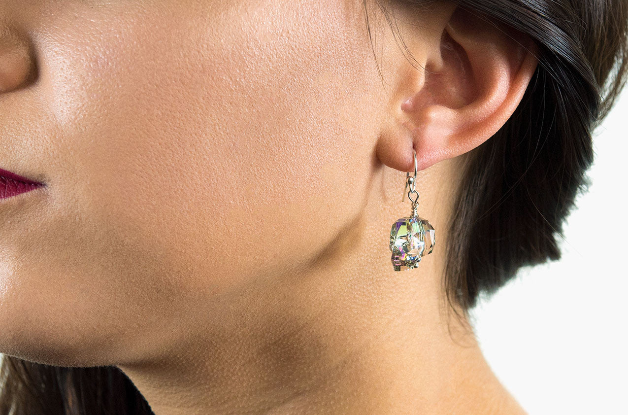 Model wearing Lovely Bones Swarovski Skull earrings Rainbow Crystal with sterling silver earwires