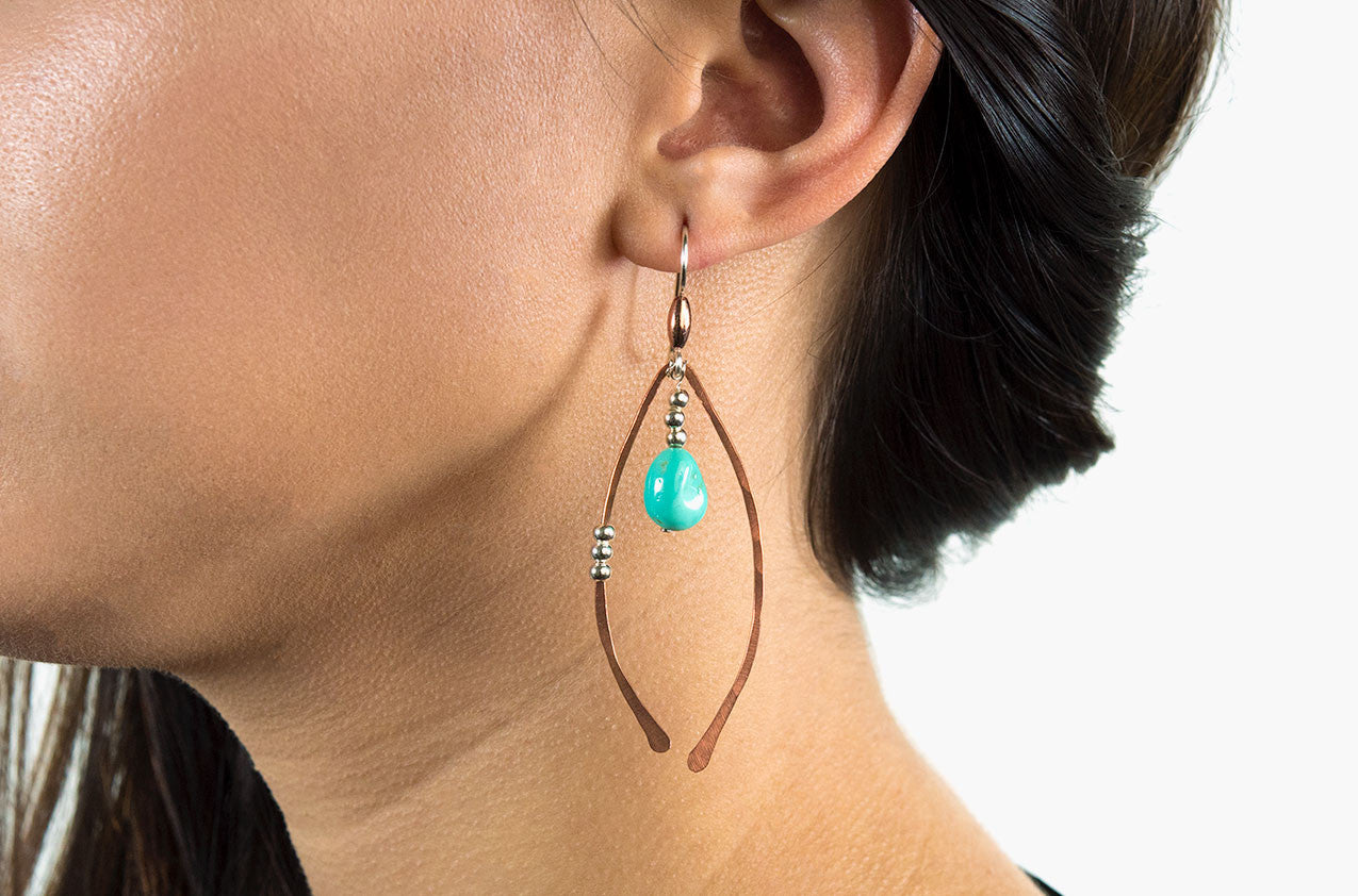 Model wearing Metal & Stone. Artisan arches earrings Copper/silver earwires