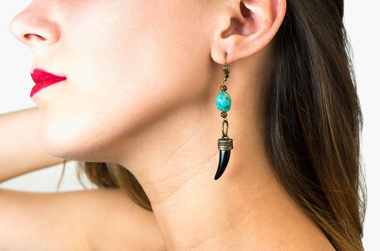 Model wearing Metal & Stone. Brass and turquoise earrings