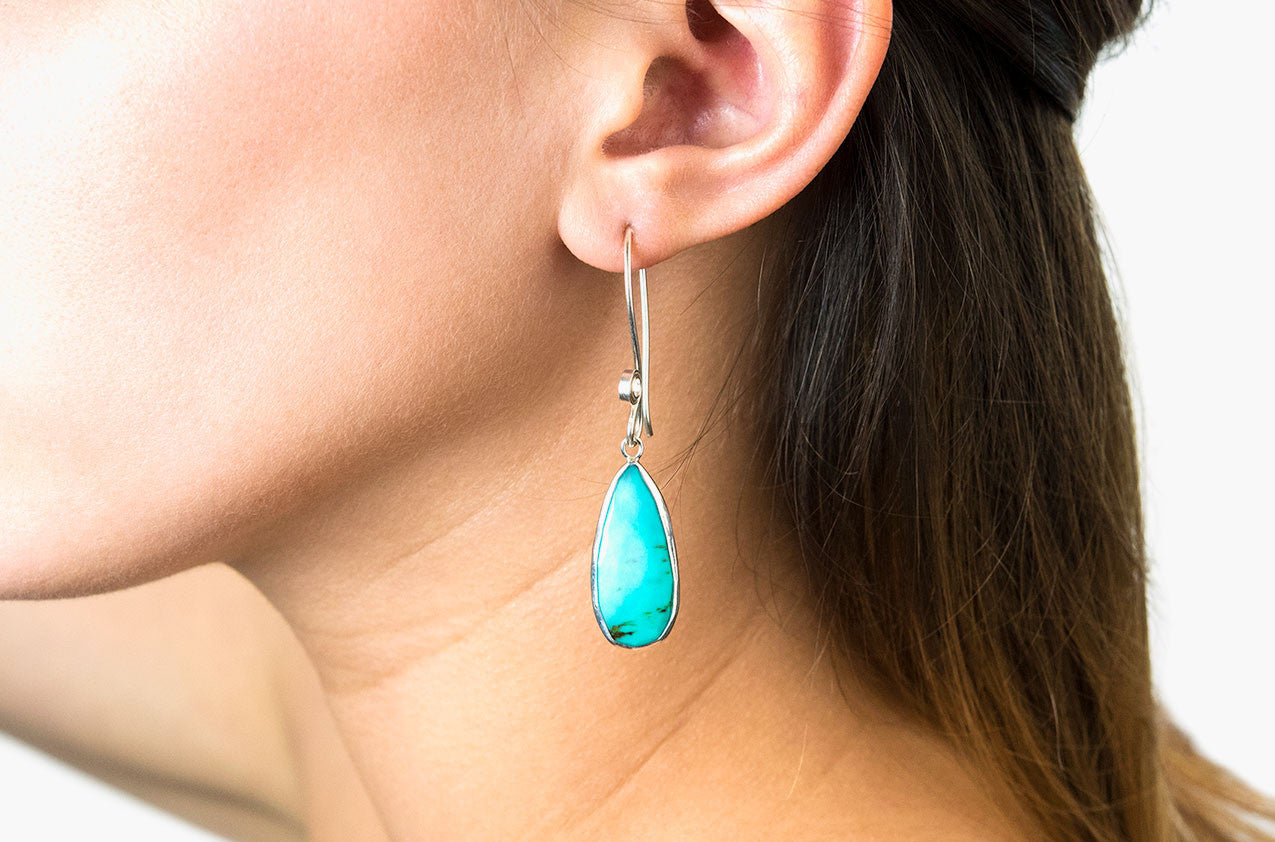 Model wearing Silver & Stone. Turquoise drop earrings