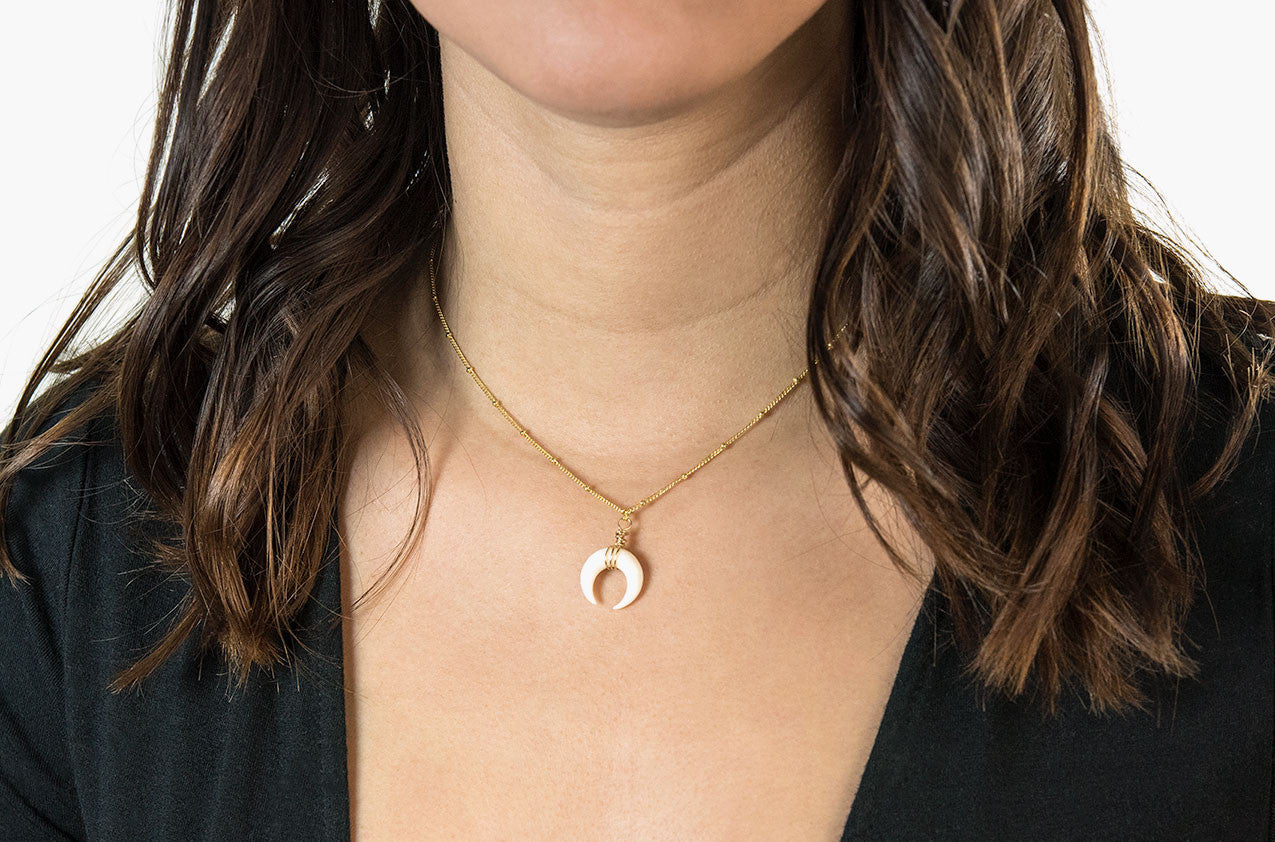 Model wearing Little Big Horn. Mini crescent necklace ivory with gold