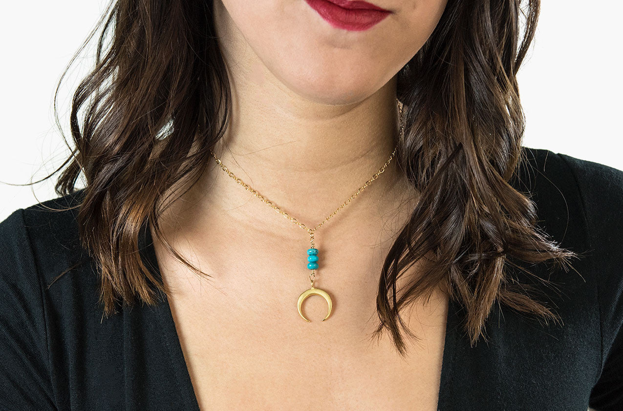Model wearing Metal & Stone. Turquoise and precious metal crescent gold