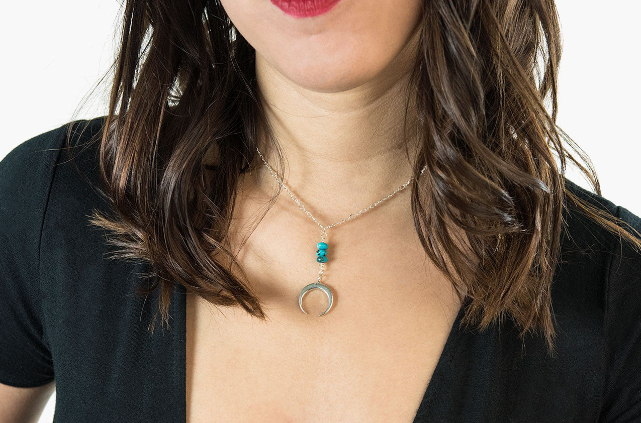 Model wearing Metal & Stone. Turquoise and precious metal crescent silver