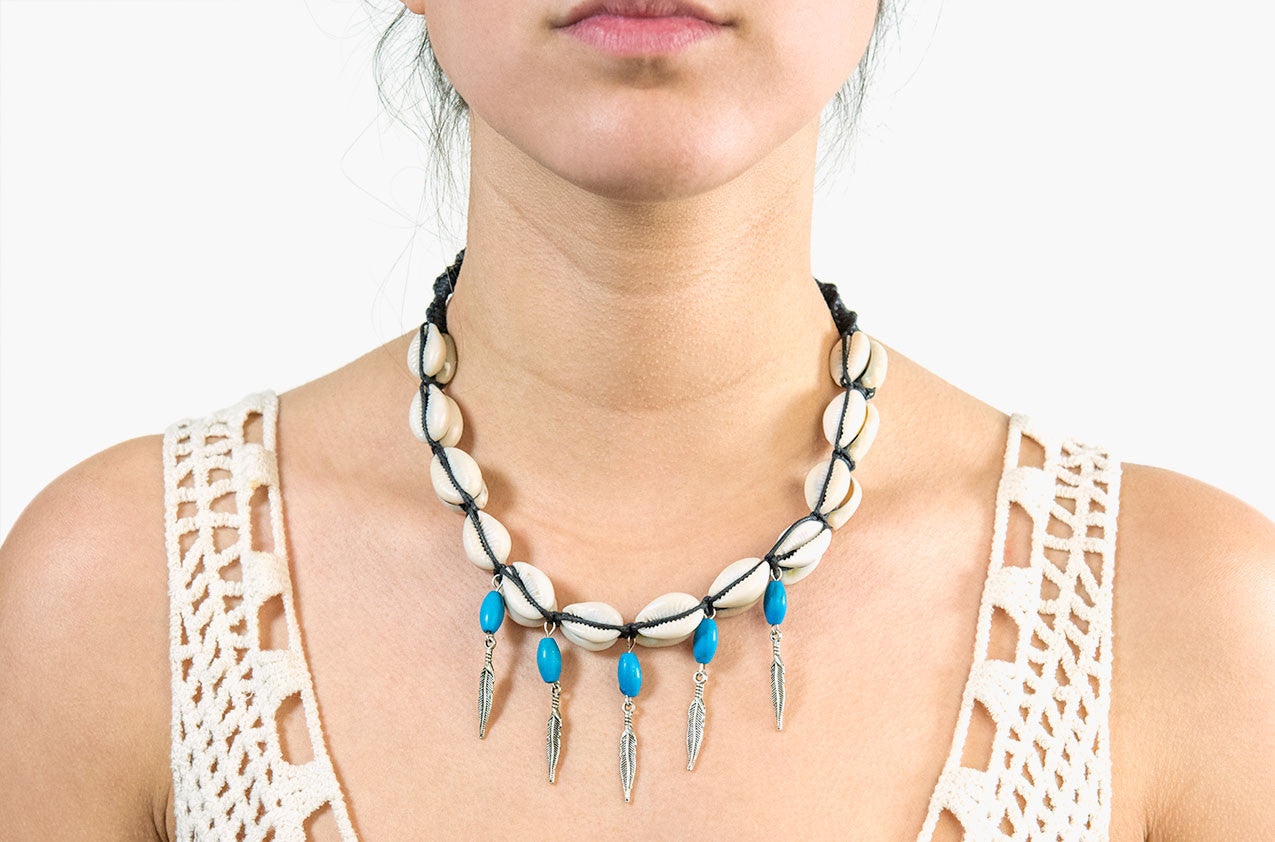 Model wearing Shell, turquoise and arrow charm necklace