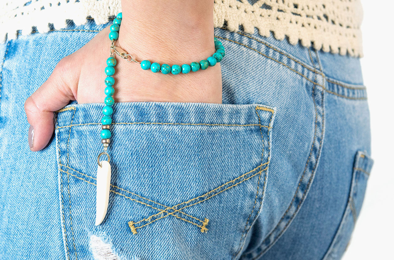 Model wearing Stone and Bone. Turquoise and spike bracelet