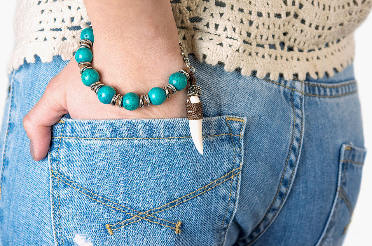Model wearing Stone & Bone. Turquoise and tooth bracelet